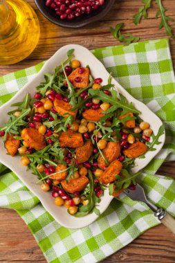 Mercimek, nar ve roketli tatlı patates salatası. Üst Manzara. Doğal ahşap zemin.