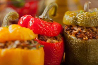 Peynirli, biberli, pirinçli ve kıymalı renkli. Ön manzara. Doğal ahşap zemin.