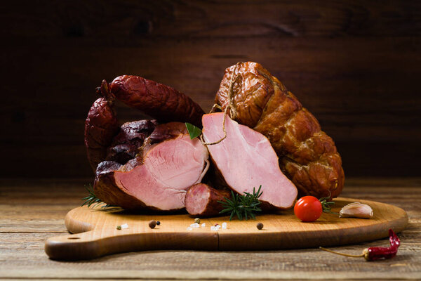 Smoked pork on wooden board. Different types of meat.