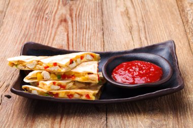 Tavuk ile Quesadilla, guacamole veya salsa sosuyla servis edilir..