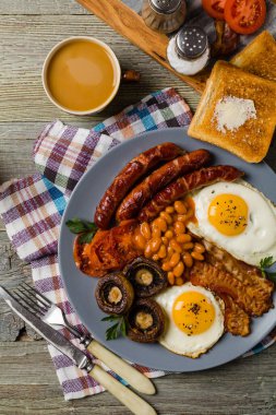 Tam İngiliz kahvaltısı, sosis, mantar, fasulye ve sahanda yumurta. Üst görünüm. 