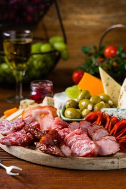 Et ve peynir tahtası. Pek çok ülkeden nefis peynirlerin ve sosislerin karışımı. Eklemek için zeytin, fındık ve sos. Tütsülenmiş ve olgunlaşmış soğuk kesimler, mavi peynirler, baharatlı ve hafif. Üst veya ön görünüm.