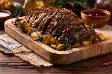 Bütün domuz boynunu kızarttım. Soğan dilimleriyle doldurulmuş. Fırında patatesle servis edilir. Doğal ahşap zemin