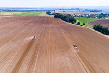 Traktörler harrownig büyük kahverengi alan üzerinde havadan görünümü