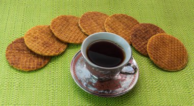 Stroopwafels in the shape of an arch arranged on the table with a coffee cup