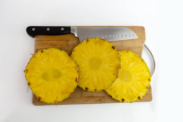 overhead shot of pineapple cuts with a knife
