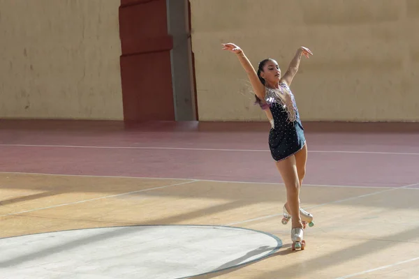 Artistik patinaj yarışmasında kollarını açmış güzel bir kız.