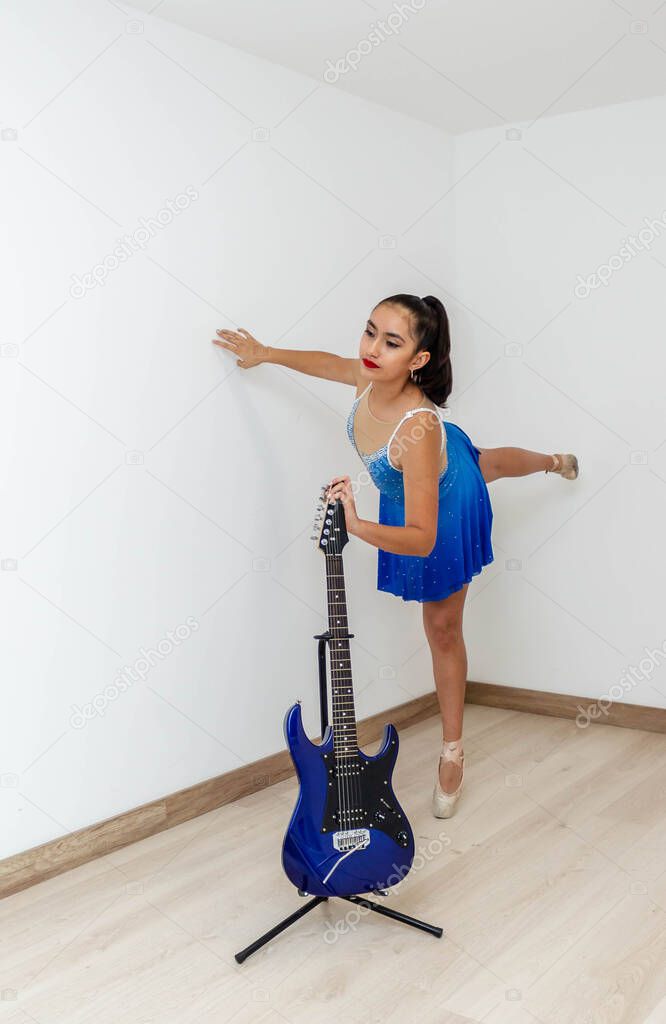 Stylish girl who is in a dance position with her outfit and an electric guitar in her living room