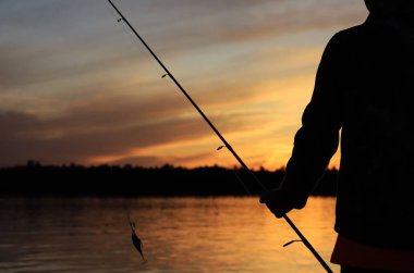Kanada 'nın vahşi göllerinde görüldüğü gibi altın bir gökyüzüne karşı gün batımı silueti. Balıkçılık ve tatil ruhu bol, doğanın güzelliği takdir edilir ve takdir edilir. Ruhun ve aklın özgürlüğü