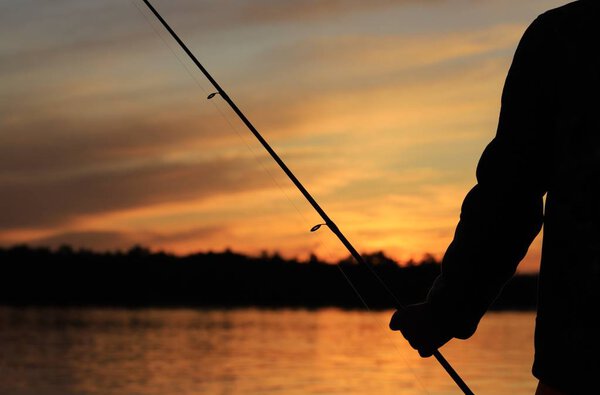 Силуэт заката на фоне золотого неба, как на диких лаках Канады. Рыбалка и дух праздника процветают, красота природы ценится и восхищается. Свобода души и разума