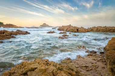Knysna kafaları kayalar, Hint Okyanusu dalgaları aracılığıyla günbatımı, Bahçe rota, Güney Afrika taşlara sahil