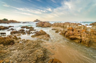Knysna kafaları kayalar, Hint Okyanusu dalgaları aracılığıyla günbatımı, Bahçe rota, Güney Afrika taşlara sahil
