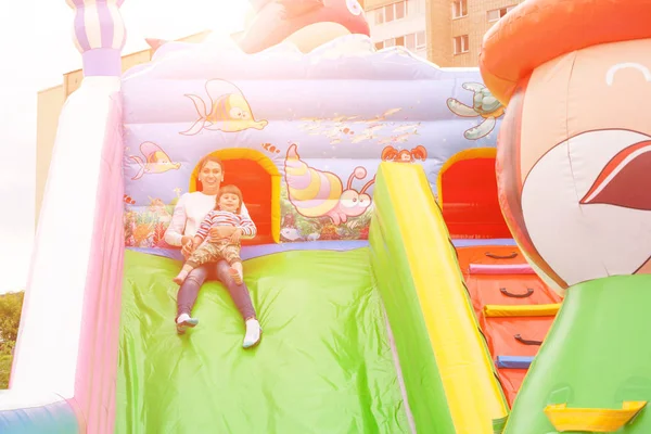 Anne ve çocuk şişme bir kalede bir slayt sürme