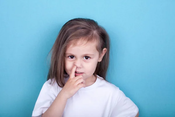 mavi arka plan üzerinde burnunda parmak ile küçük kız