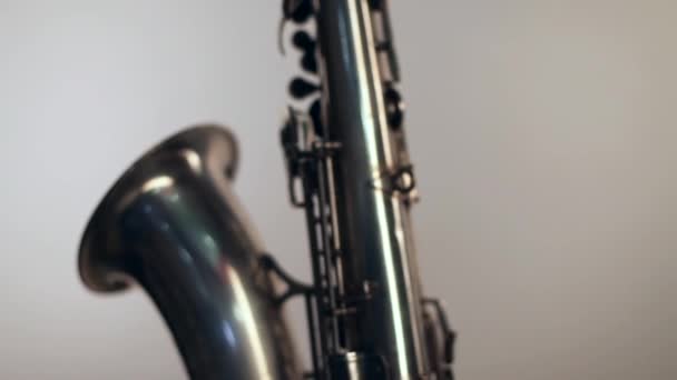 Saxofon på vit bakgrund, rotation, slinga — Stockvideo