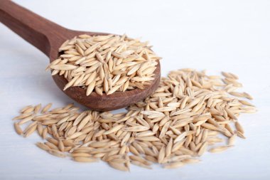 beyaz zemin üzerine tahta kaşık yulaf gevreği