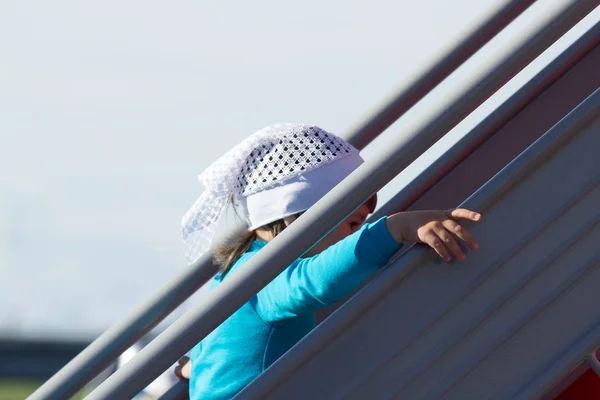 Küçük bir kız merdivenleri tırmanıyor.