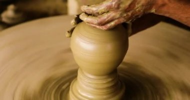 Pot Maker Close Up Shot alan güzel derinliği ile arka planda birçok bitmiş Piggy-Bank ile Kil bir Piggy-bank yapma