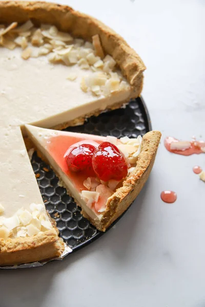 Coconut custard pie with strawberry jam on marble background