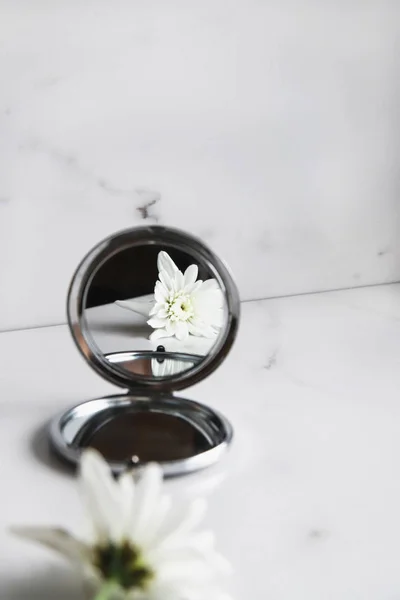 白い花は 光の大理石の背景に鏡に反映されています 美容コンセプト ロイヤリティフリーのストック写真