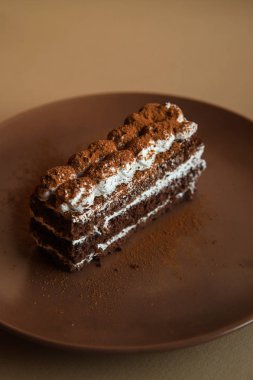 Kahverengi arka plan üzerinde Tiramisu kek. Minimal modern tatlı konsepti