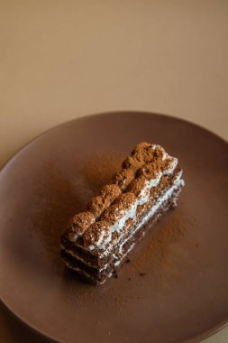 Kahverengi arka plan üzerinde Tiramisu kek. Minimal modern tatlı konsepti