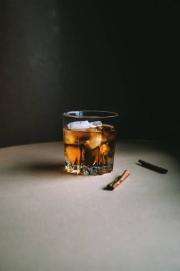 Buz küpleri ve tarçın koyu arka plan üzerinde sopa ile Viski. Sonbahar alkol kavramı