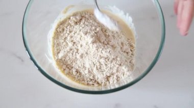 Şef sıvı malzemelere yulaf unu ekler. Kişi para yapar. Glutensiz