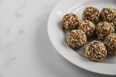 Fotokopi alanı olan enerji topları. Ev yapımı sağlıklı tatlı hurma, fındık, kuru meyve ve kakao ile pişirilir. Mermer arka planda organik kuru meyve atıştırmalıkları