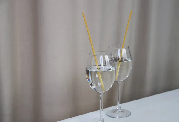 Ecological straws from pasta for drinks. Natural spaghetti tubules and water glasses. Plastic free and zero waist concept