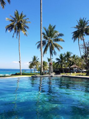 Sonsuzluk havuzu ve palmiye ağaçlarıyla, Bali, Endonezya resort seyahat arka plan için kopya alanı ile Hint Okyanusu.