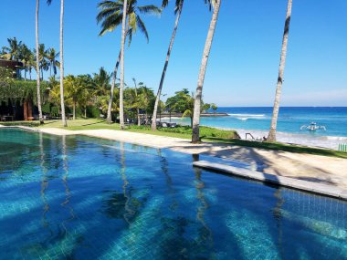 Sonsuzluk havuzu ve palmiye ağaçlarıyla, Bali, Endonezya resort seyahat arka plan için kopya alanı ile Hint Okyanusu.