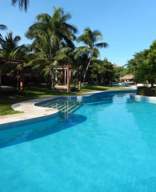 Tropik yeşillikler ile palm ağaçlar ve havuzu kolaylıklar bir Karayipler çare Riviera Maya Cancun, Meksika için üzerinde.