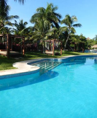 Tropik yeşillikler ile palm ağaçlar ve havuzu kolaylıklar bir Karayipler çare Riviera Maya Cancun, Meksika için üzerinde.