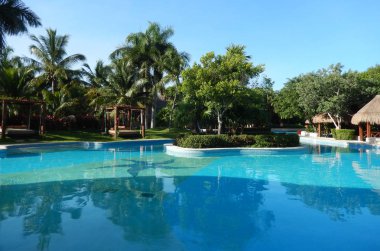 Tropik yeşillikler ile palm ağaçlar ve havuzu kolaylıklar bir Karayipler çare Riviera Maya Cancun, Meksika için üzerinde.