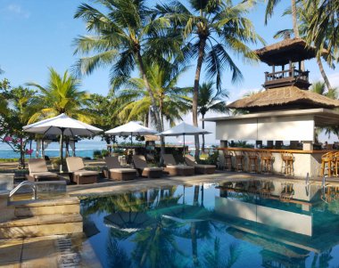 Havuz ve bar kolaylıklar için Candidasa beach Resort Bali, Endonezya, palmiye ağaçları ile çevrili arka planlar seyahat.