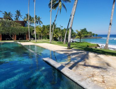 Sonsuzluk havuzu ve palmiye ağaçlarıyla, Bali, Endonezya resort seyahat arka plan için kopya alanı ile Hint Okyanusu.