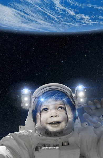 Barn astronaut viftande på jorden från rymden — Stockfoto