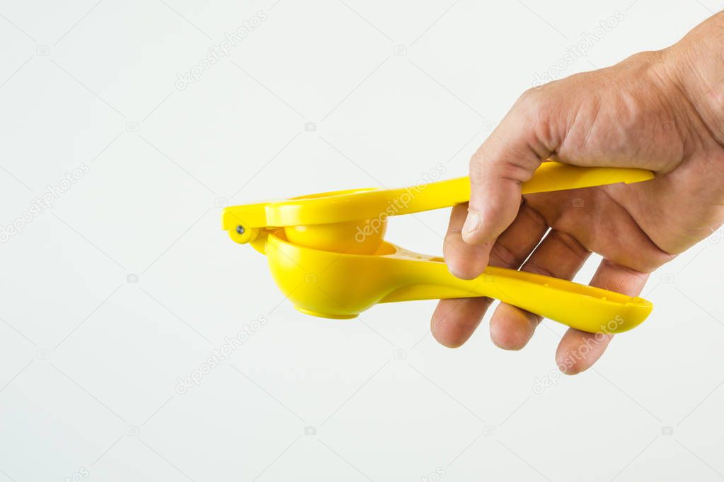 hand with manual lemon juicer on White background