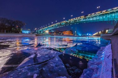 Bir kış gecesinde nehrin karşısındaki Kurtarıcı İsa Katedrali'nden ataerkil köprü.