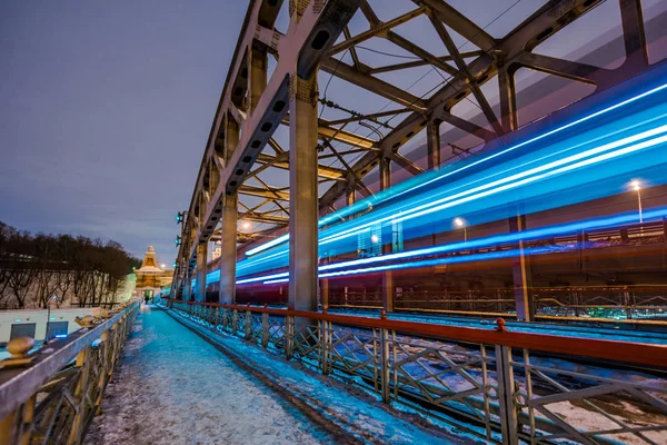 Hochgeschwindigkeitszug mit Bewegungsunschärfe auf dem Hintergrund der Eisenbahnbrücke im Dunkeln — Stockfoto