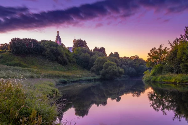 Церковь на реке на восходе солнца — стоковое фото