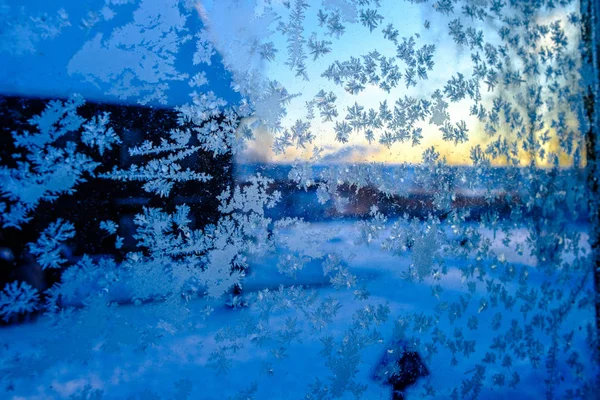 Окно стекло с ледяными узорами. Сумерки за окном . — стоковое фото