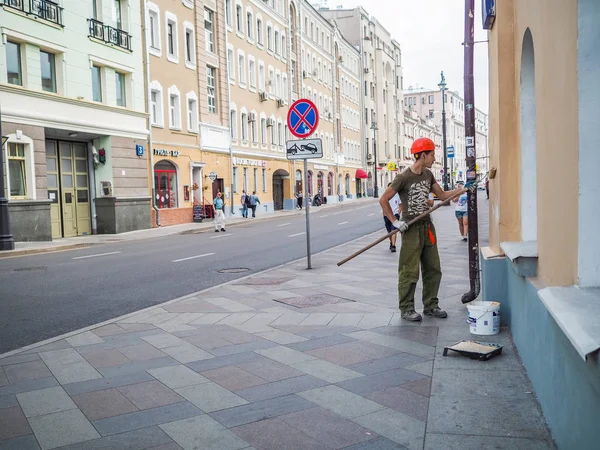 Живописец на улице в городе красит стену — стоковое фото