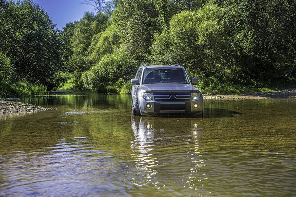 Внедорожник в воде, преодолевая реку
.
