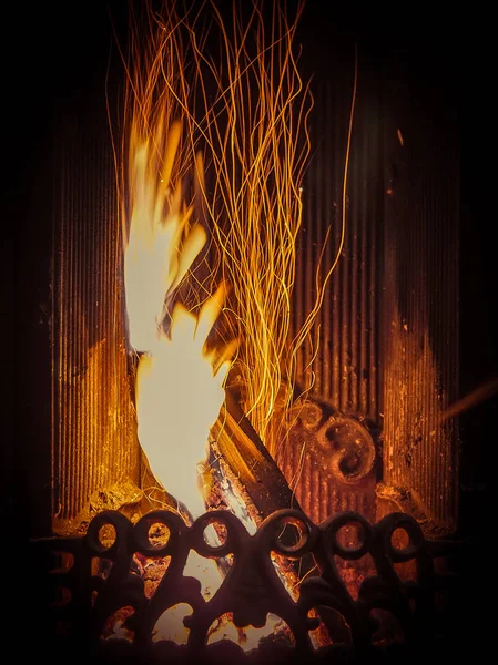 Fascinating spectacle of the bizarre magical dance of sparks and fire in the fireplace insert.