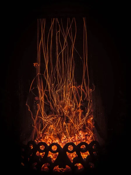 暖炉の挿入物で火花と火の奇妙な魔法のダンスの魅惑的な光景. — ストック写真