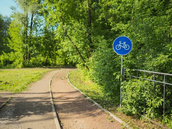 カエデの葉の間に公園内の自転車道に署名します。夏晴れd — ストック写真
