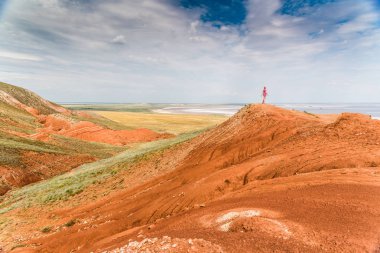 Tuzlu göl Baskunchak arka planda Bolşoy Bogdo dağının kenarında duran bir turist kız.