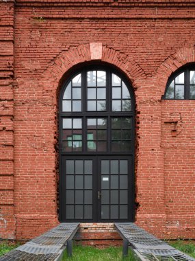 Araba girişi için ona bağlı metal raylar ile eski bir kırmızı tuğla duvarda Fransız kemerli pencere